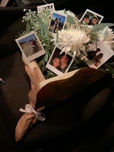 a bouquet of flowers and pictures on a black surface with white ribbon around the edges