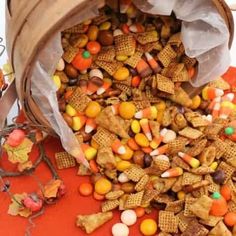 a bag full of corn and candy on top of a table next to some pumpkins