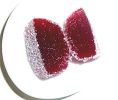 two pieces of fruit sit on a plate covered in powdered sugar and watermelon