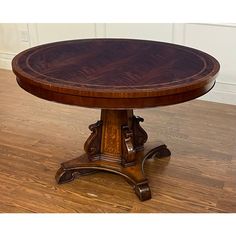 a round wooden table sitting on top of a hard wood floor