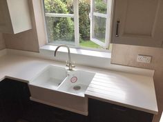 a white sink sitting under a window in a kitchen