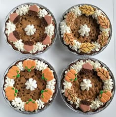 four pies are arranged in the shape of wreaths with leaves and cookies on them