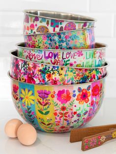 three bowls with flowers painted on them next to eggs