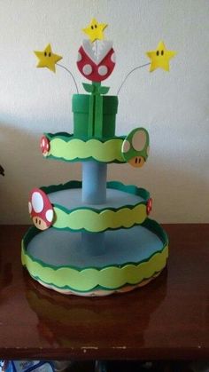 a cake that is sitting on top of a table with mario and luigi paper decorations