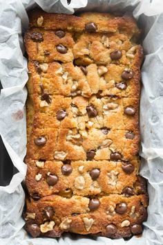 a loaf of bread with chocolate chips on top in a paper lined baking pan, ready to be baked