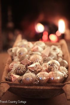 a wooden bowl filled with ornaments on top of a table