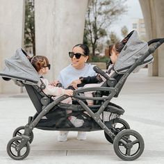 an adult and two children sitting in a stroller