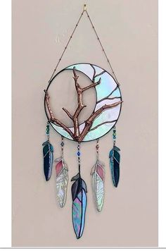 a metal and glass dream catcher hanging on a wall