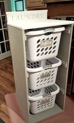 laundry baskets are stacked on top of each other in this kitchen storage unit with the word laundry written on it