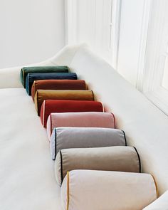 a row of pillows sitting on top of a white bed