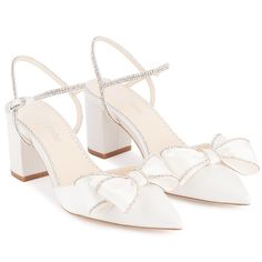 a pair of white shoes with bows on them