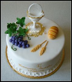 a white cake with grapes and other items on it