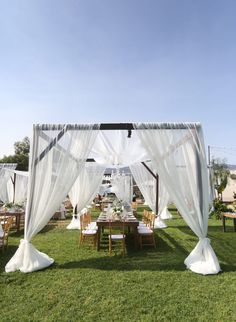 an outdoor wedding set up with white drapes