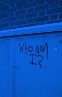 graffiti on the side of a building that says who am i?