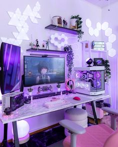 a desk with a computer monitor, keyboard and mouse on it in front of a purple wall