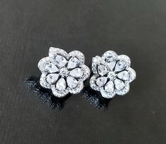 pair of diamond flower earrings on black background