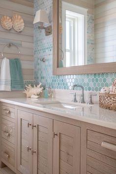 a bathroom with blue and white tiles on the walls, wooden cabinetry, and a large mirror