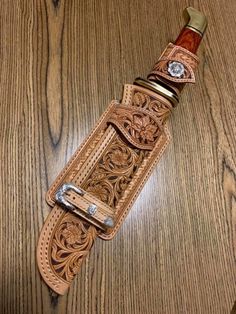 a brown leather belt on top of a wooden table