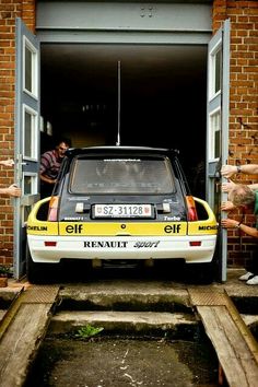 a yellow and white car parked in front of a brick building