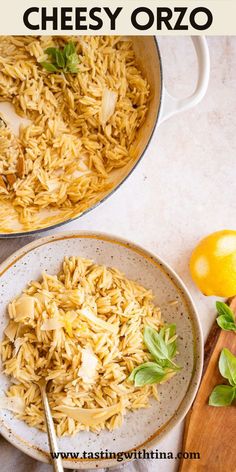 two plates filled with pasta on top of a table next to lemons and basil