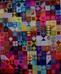 a colorful quilt with many different colors and patterns on it's sides, including squares