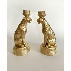 two golden candlesticks sitting on top of each other with animals in the middle