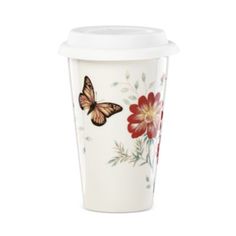 a coffee cup with a butterfly painted on the side and flower designs on the outside