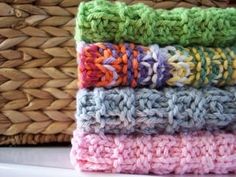 four crocheted dishcloths stacked on top of each other in different colors