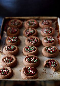 chocolate cookies decorated with sprinkles on a baking sheet, ready to go into the oven