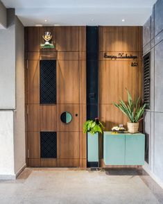 the entrance to an office building with wood paneling and green plant in front of it