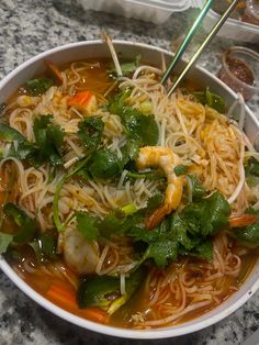 a white bowl filled with noodles and vegetables