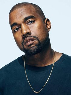 a close up of a person wearing a necklace and looking off to the side with a serious look on his face