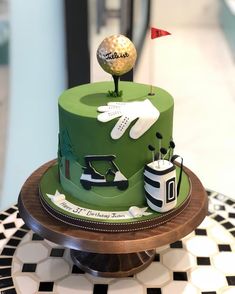 a green cake with golf themed decorations on it and a golf ball sitting on top of the cake