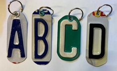 three key chains with the letters abcd on them