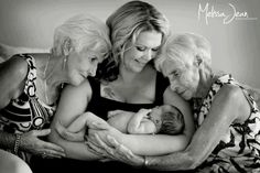 an older woman holding two younger women and a baby