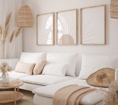 a living room filled with white furniture and large pictures hanging on the wall above it