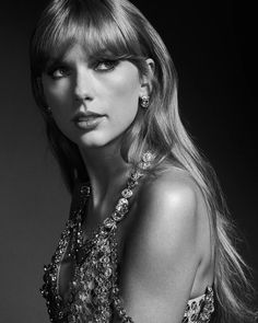 black and white photograph of a woman with long hair wearing an evening gown, necklace and earrings