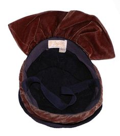 "Item: This is a classic tilt hat fashioned from chocolate brown felt and contrasting caramel brown velveteen accents. It was made in the late 1930s or early 1940s and is in Excellent condition. There is a chin strap you can use on windy days or it can be tucked into the hat should you decide not to use it. Be sure to Favorite this piece and check our listings for lots more vintage hats! Label: Dahlia Model, San Francisco Cal., 22 1/2 Measurements: 21\" inner circumference, 3\" crown height, 7\" Vintage Brown Formal Hat, Brown Cloche Hat For Formal Occasions, Brown Formal Cloche Hat, Formal Brown Cloche Hat, Brown Brimmed Evening Hat, Evening Brown Brimmed Hat, Brimmed Brown Hat For Vintage Events, Brown Brimmed Hat For Vintage Events, Vintage Brown Cloche Hat