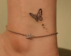 a small tattoo on the ankle of a woman's foot with a butterfly flying above it