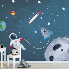 an astronaut wall mural in a child's room with space and stars on the walls