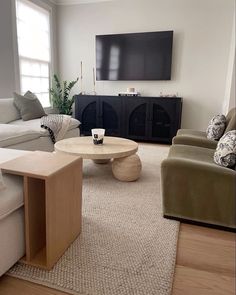 a living room filled with furniture and a flat screen tv mounted above the entertainment center