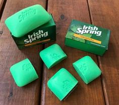 four soap bars sitting on top of a wooden table next to a box of irish spring soap