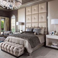 a bedroom with a large bed and chandelier