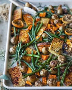 a white dish filled with potatoes and green beans