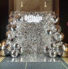 a large glass sculpture sitting on top of a tiled floor next to a wall filled with lights