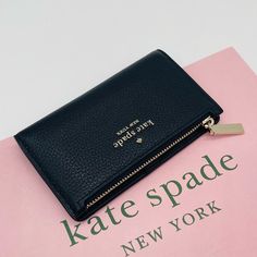 Brand New With Tag Kate Spade Leila Small Slim Bifold Wallet Details Color: Black 3.1" H X 5.5 Wx 0.9" D Pebbled Leather Metal Pinmount With Spade Logo Two Way Spade Jacquard Lining 5 Credit Card Slots, Id Window, 2 Slip Pockets Exterior Top Zip Coin Compartment On Front Of Wallet Snap Closure Dust Bag Not Included Imported Style # Wlr00395 Kate Spade Bifold Coin Purse, Chic Kate Spade Bifold Wallet, Kate Spade Coin Purse For Daily Use, Kate Spade Evening Wallet With Card Slots, Chic Kate Spade Wallets With Interior Card Slots, Chic Kate Spade Wallet For Travel, Elegant Kate Spade Coin Purse For Travel, Elegant Kate Spade Travel Coin Purse, Chic Kate Spade Wallets For Travel