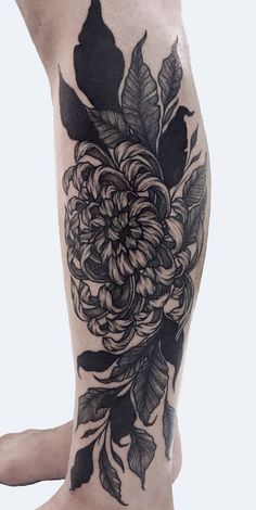 a woman's leg with flowers and leaves on it