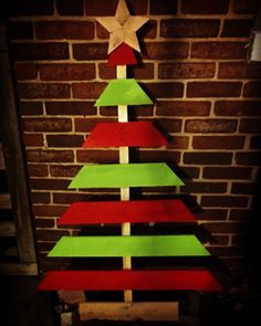 a christmas tree made out of wooden planks and painted red, green and white