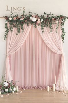 a pink backdrop with roses and greenery on it for a wedding ceremony or reception