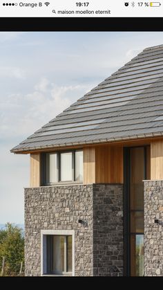 an image of a house that is made out of stone and has wood shingles on the roof